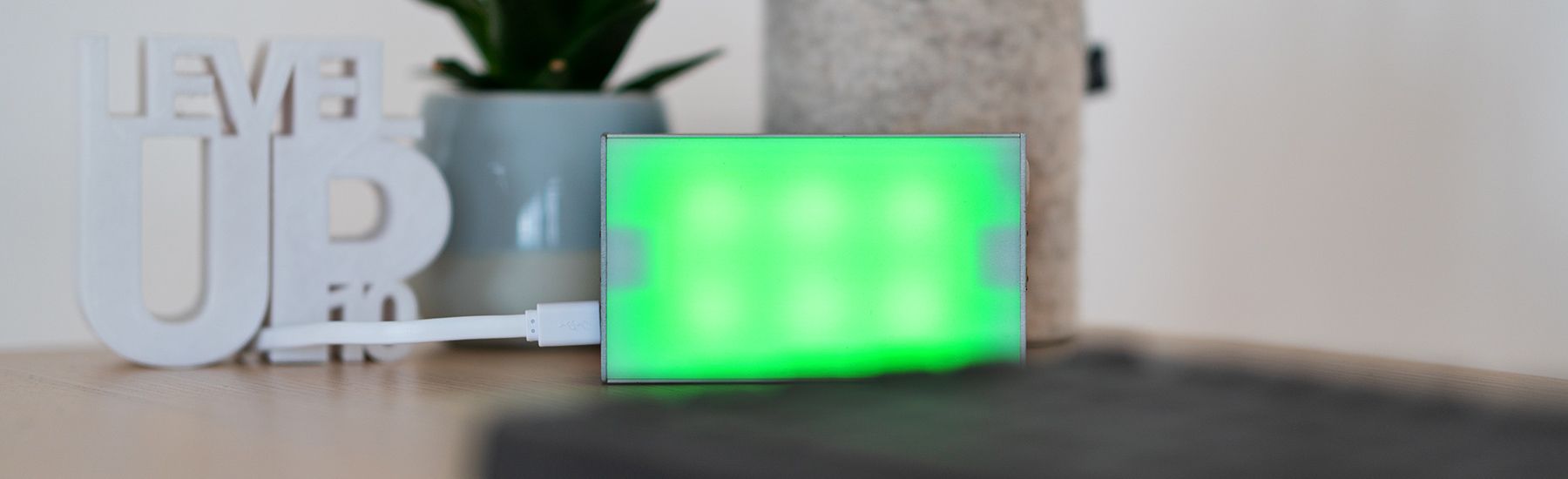 CO2-Ampel steht auf dem Schreibtisch und leuchtet grün.