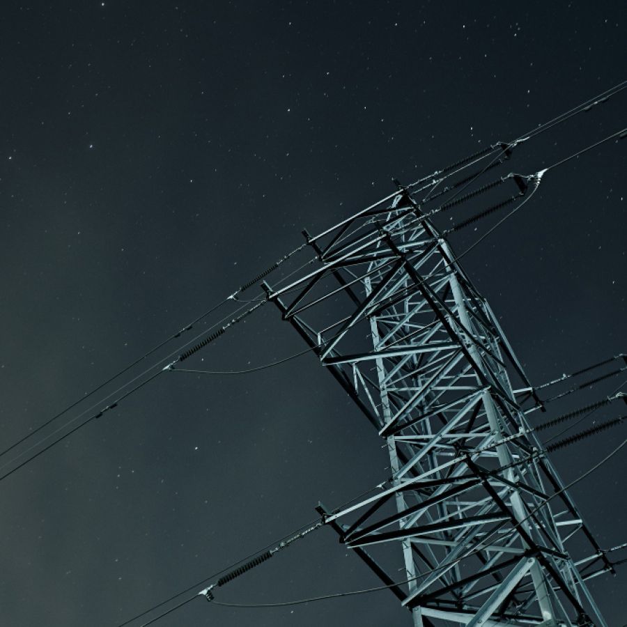 Die Temperaturüberwachung mit Alarm verfügt auch über eine Offline-Alarmierung. Das Bild zeigt einen Strom-Mast von unten fotografiert. Im Hintergrund ist  der Nachthimmel mit leuchtenden Sternen zu sehen.